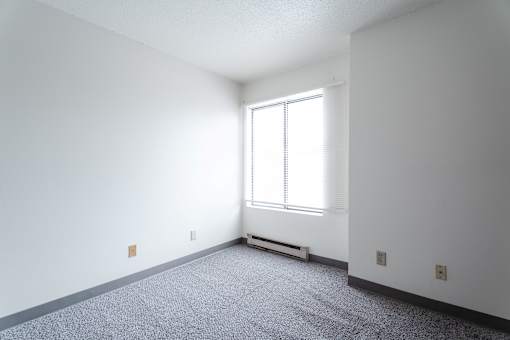 A room with a window and a radiator on the floor. at Bristol Ridge, Urbandale, Iowa