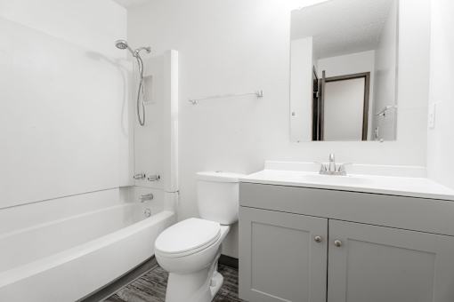 A white bathroom with a toilet, sink, and bathtub. at Bristol Ridge, Urbandale