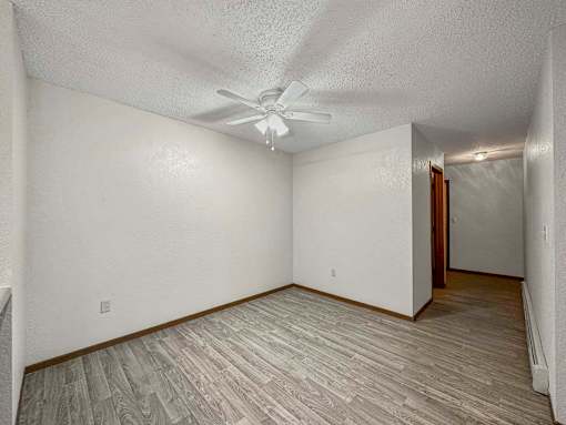 the spacious living room with a ceiling fan and wood flooring at Creekstone Falls, Sioux Falls, SD