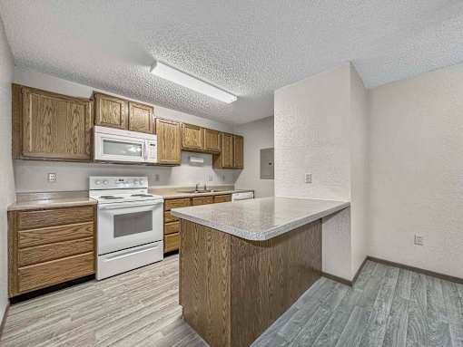 a kitchen with white appliances and wooden cabinets at Creekstone Falls, South Dakota, 57106