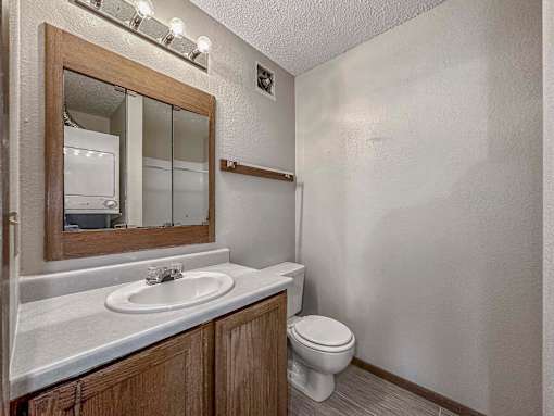 a bathroom with a toilet sink and a mirror at Creekstone Falls, South Dakota, 57106