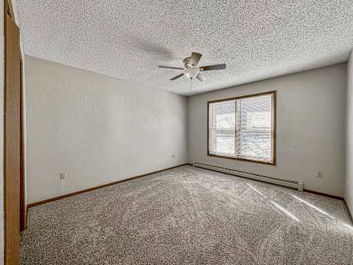 an empty living room with a ceiling fan and a window at Creekstone Falls, South Dakota, 57106