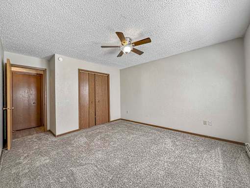 an empty living room with a ceiling fan at Creekstone Falls, Sioux Falls, SD