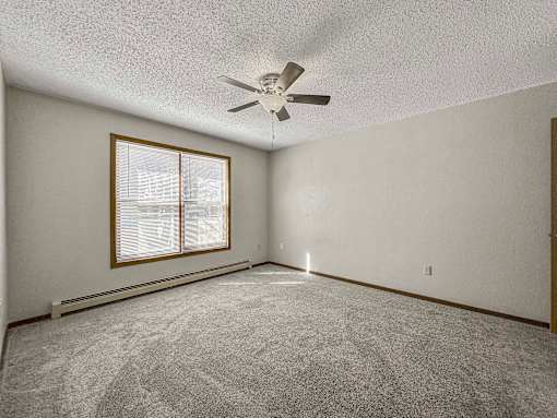 an empty living room with a ceiling fan and a window at Creekstone Falls, South Dakota, 57106