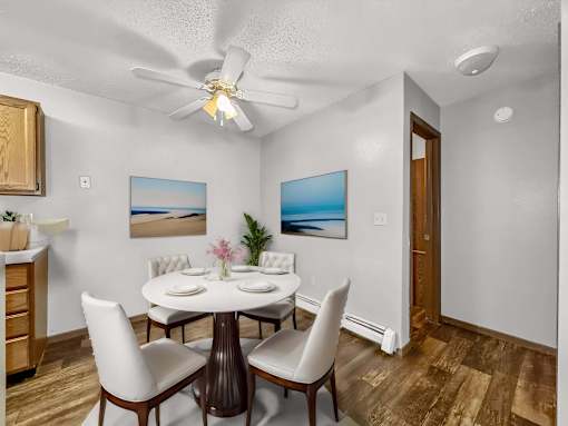 a dining room with a table and chairs and a ceiling fan at Creekstone Falls, Sioux Falls