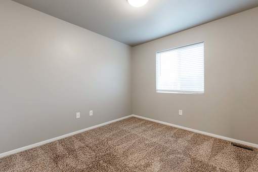 A room with a carpeted floor and a window with blinds. at Danamere Village, Carlisle