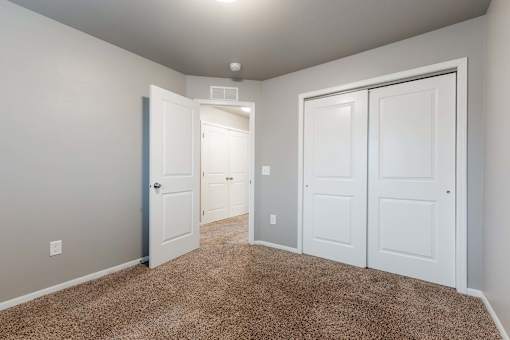 A room with white doors and carpeted floor. at Danamere Village, Iowa, 50047