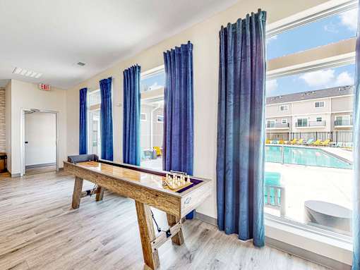 a games room with a pool table and blue curtains at Forge65, Pleasant Hill, IA, 50327