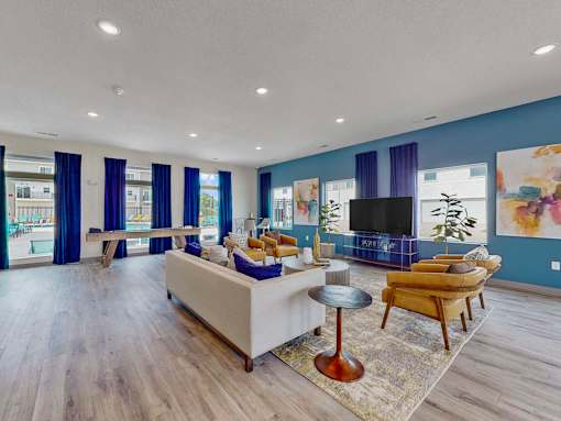 a living room with blue walls and a couch and a tv at Forge65, Pleasant Hill, IA, 50327
