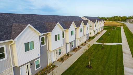 a row of small white houses with green grass at Forge65, Iowa, 50327