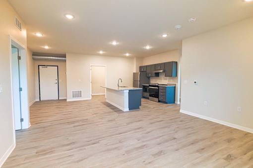 the living room and kitchen of a new home with wood flooring at Forge65, Pleasant Hill, IA, 50327