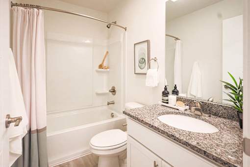 a bathroom with a sink and a shower and a toilet at Forge65, Pleasant Hill, Iowa