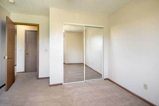 A room with a sliding door and a brown door at Hunters Run Apartments, IA, 50208