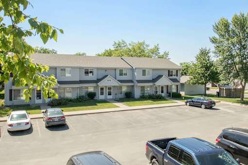 A building with a parking lot in front of it at Hunters Run Apartments, IA, 50208