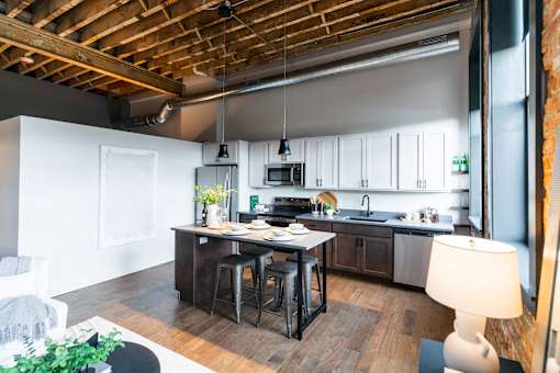 A kitchen with a wooden ceiling and a table with chairs.at Plant 1 Lofts, Iowa, 50208