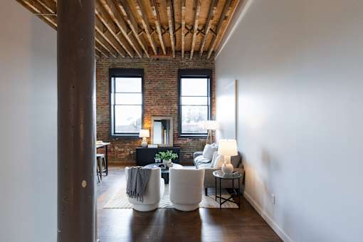 A living room with a white couch and a wooden floor.at Plant 1 Lofts, N. Newton Iowa   