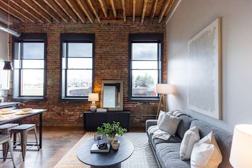 A living room with a grey couch and a round coffee table.at Plant 1 Lofts, N. Newton, IA 50208  