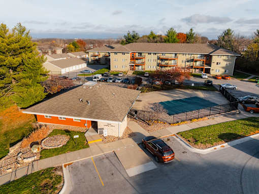A car is parked in a parking lot in front of a building. at Rosemont Place Apartments, Des Moines, 50320