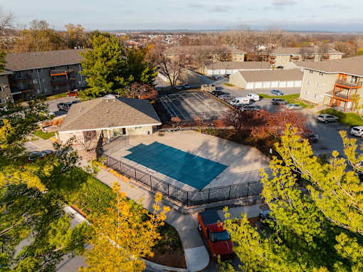 A red truck is parked by a pool in a residential area. at Rosemont Place Apartments, Iowa, 50320