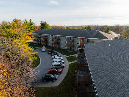 A parking lot with cars and a building in the background. at Rosemont Place Apartments, Des Moines, 50320