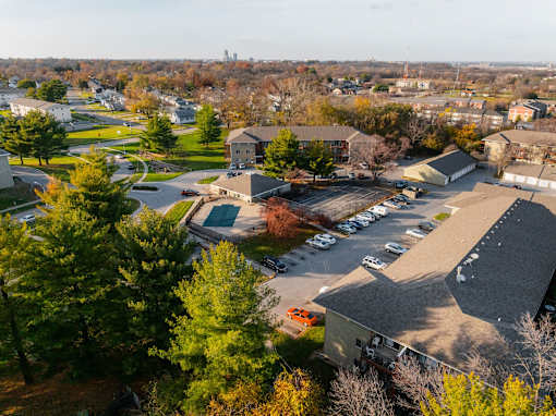 A parking lot is in the foreground of a residential area at Rosemont Place Apartments, Des Moines, IA
