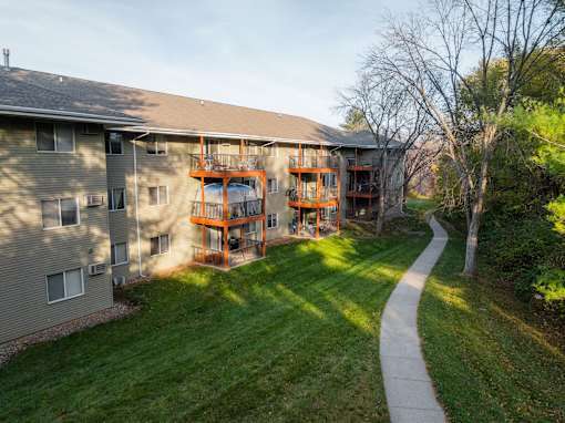 A building with a balcony and a walkway in front of it at Rosemont Place Apartments, Des Moines