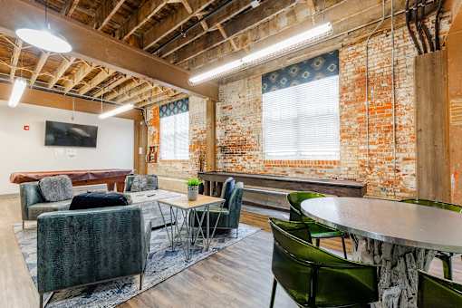 A room with a couch, chairs, and a table at Spaulding Lofts Apartments, IA, 50112