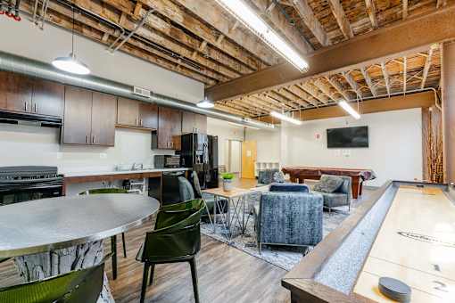 A room with a pool table and a bar area at Spaulding Lofts Apartments, Grinnell, IA