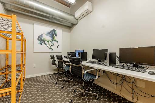 A room with a desk, chairs, and a painting of a horse at Spaulding Lofts Apartments, Grinnell, IA
