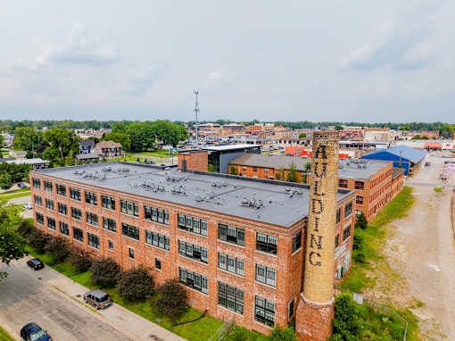 An aerial view of a large brick building with the word at Spaulding Lofts Apartments, Iowa, 50112