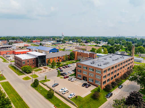 A large building complex with a parking lot in front at Spaulding Lofts Apartments, Grinnell, IA