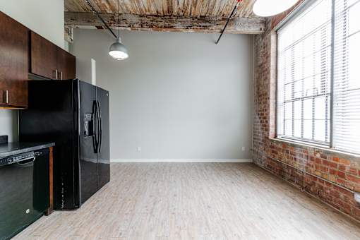 A kitchen with a black fridge and wooden cabinets.