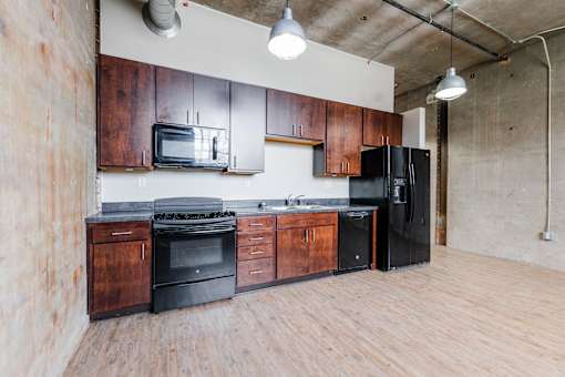 A kitchen with wooden cabinets and black appliances.