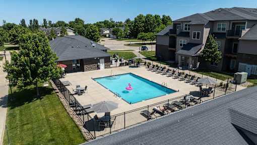 A large swimming pool surrounded by lounge chairs and umbrellas.