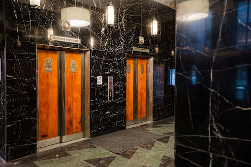 A hallway with two doors and a marble floor.
