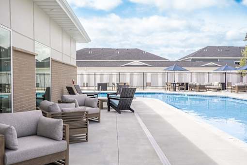A poolside area with lounge chairs and a pool.