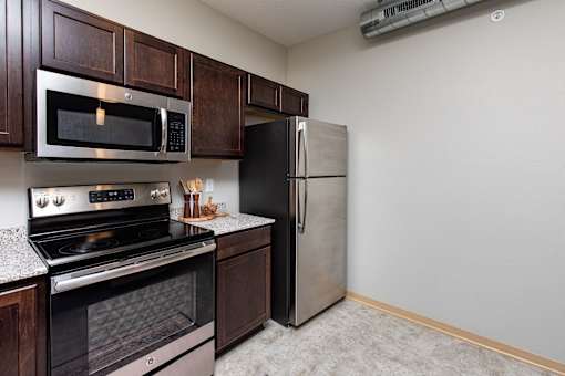 a kitchen with stainless steel appliances and a refrigerator at Lake Shore Apartments, Ankeny