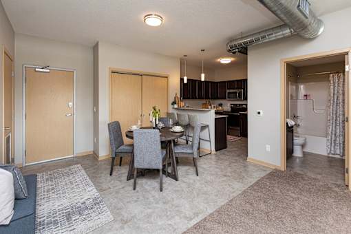 an open living room and kitchen with a dining room table and chairs at Lake Shore Apartments, Iowa, 50021