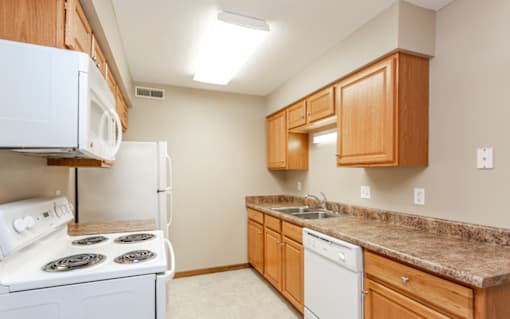 a kitchen with white appliances and granite counter tops at Lake Shore Place Apartments, Iowa, 50021