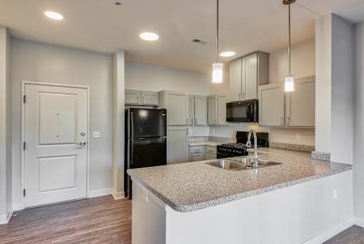A kitchen with a granite countertop and a sink.