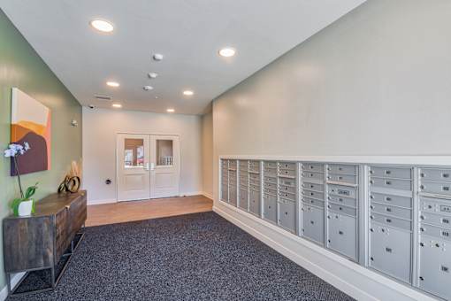 A room with a long row of mailboxes on the wall.