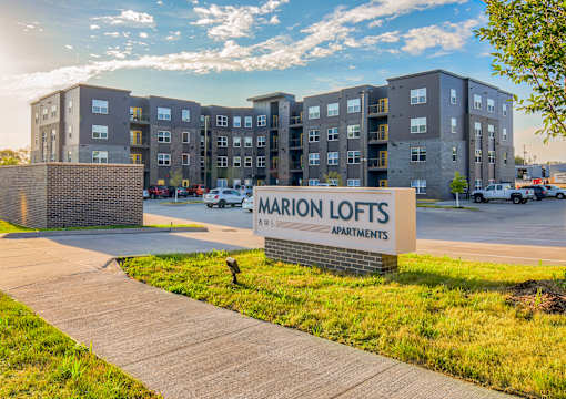 A large building with a sign that says Marion Lofts Apartments in front of it.
