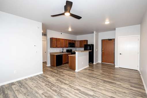 A room with a kitchen island and wooden floors at Meadowlark Place Apartments, Grimes, Iowa