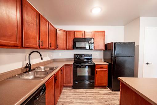 Kitchen with brown cabinets at Meadowlark Place Apartments, Grimes