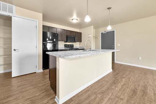 A kitchen with a pantry closet and a island counter at Melbourne Apartments in Des Moines, Iowa 50320.
