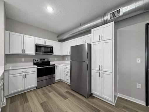 a kitchen with white cabinets and stainless steel appliances at Converge NW, Waukee, IA 50263  