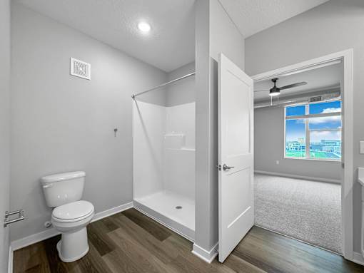 a white bathroom with a toilet and a shower at Converge NW, Waukee, IA  