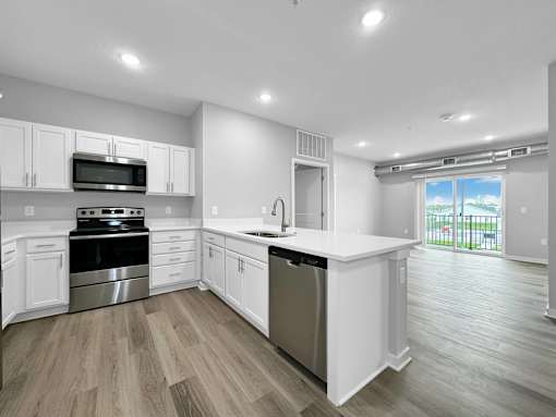a kitchen with white cabinets and stainless steel appliances at Converge NW, Waukee Iowa  