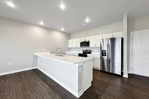 a kitchen with a white counter top and a stainless steel refrigerator at Converge NW, Waukee Iowa  