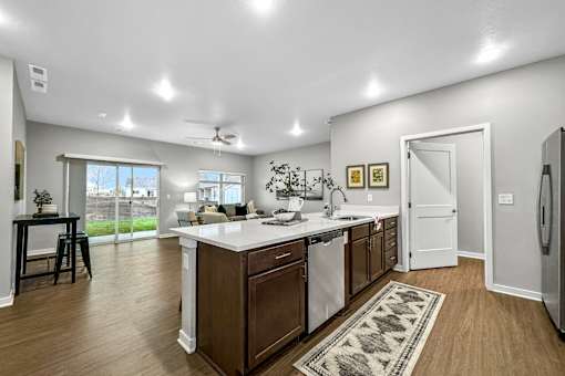a kitchen with an island and a door to a living room at Converge NW, Waukee, IA  